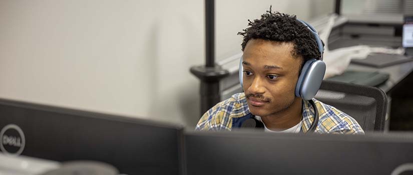 Service Desk team member taking calls while in front of his computer