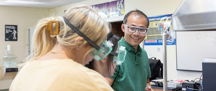 Professor and students interacting with an experiment