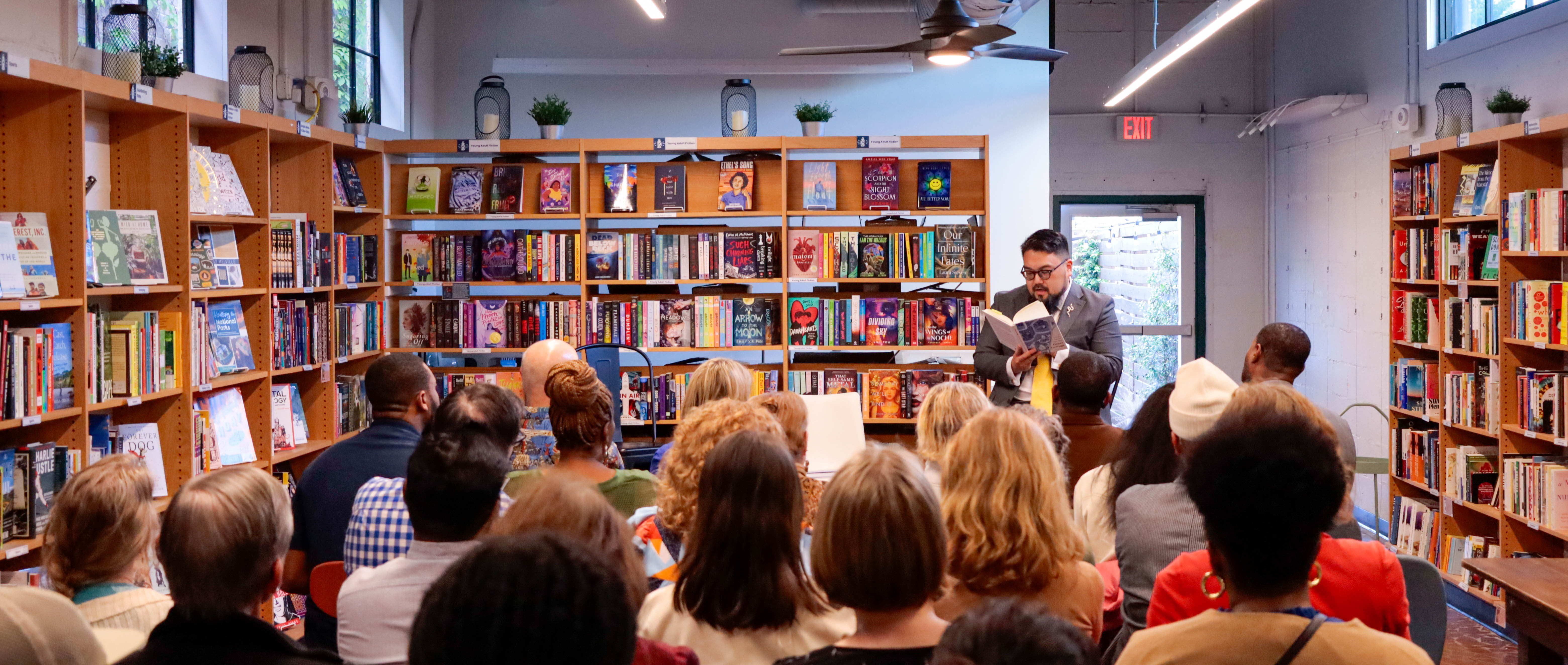 Photo of Seulghee Lee speaking to a crowed at the book launch for Seulghee Lee, Leah McClimans, and Jabari Evans