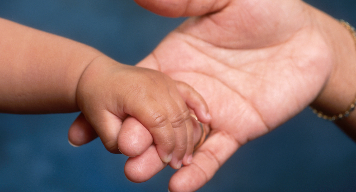 Baby hand in adult hand
