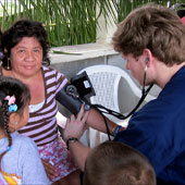 A man takes a woman's blood pressure.