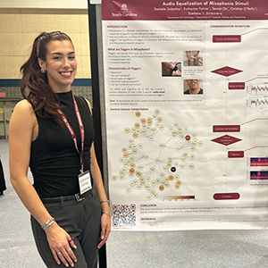 Katherine Palmer stands next to her poster titled 