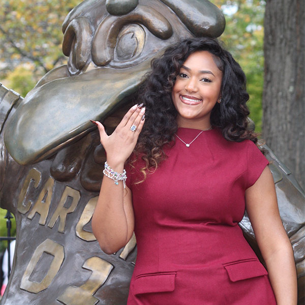 Meagan Hodges shows her USC ring standing next to the Cocky statue on campus